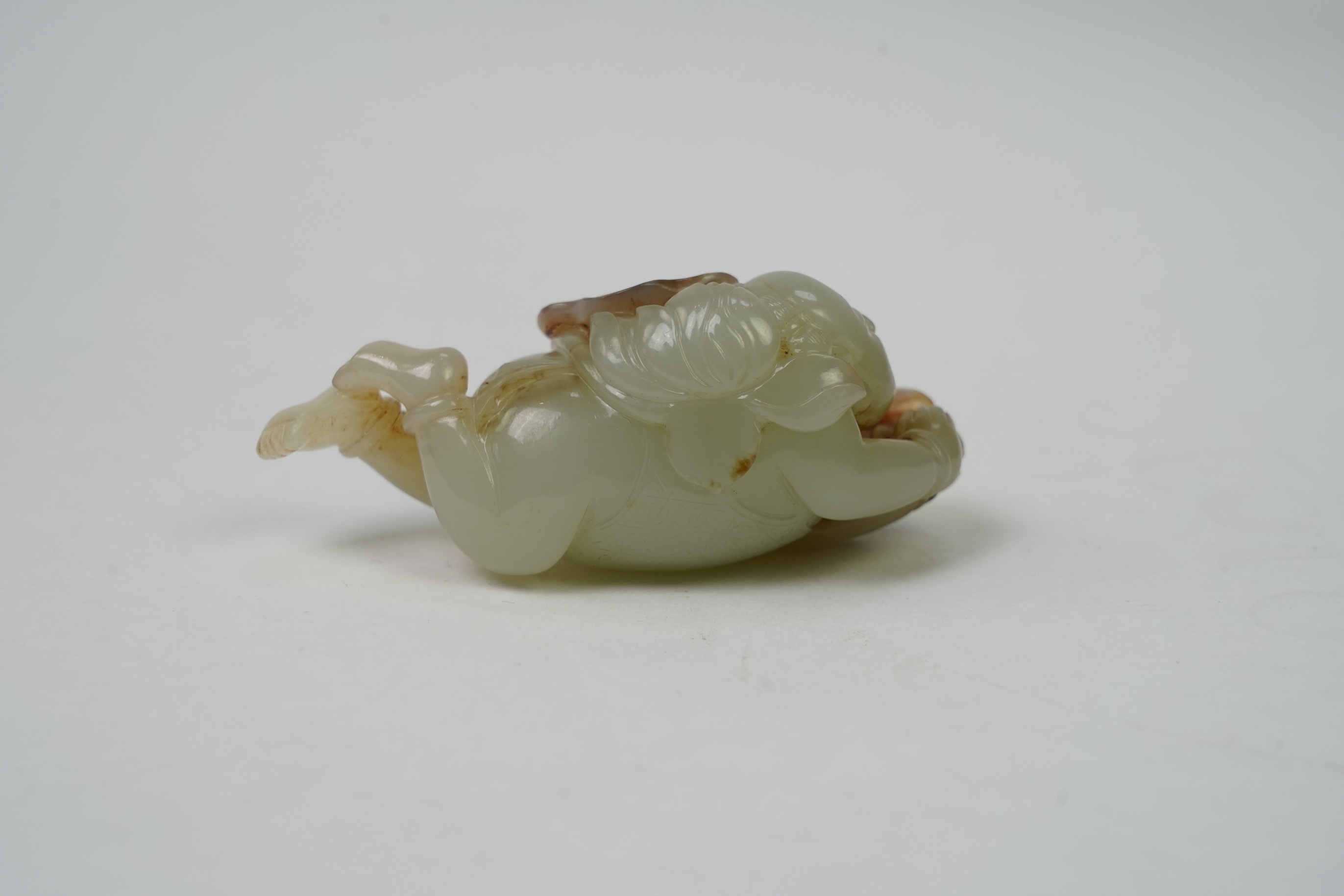 A Chinese pale celadon and russet skin jade figure of a boy and lotus